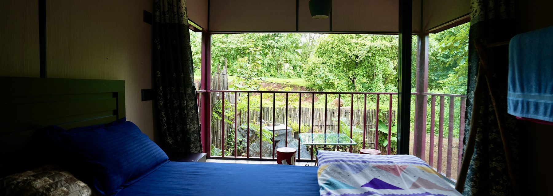 bed facing the balcony and the trees beyond