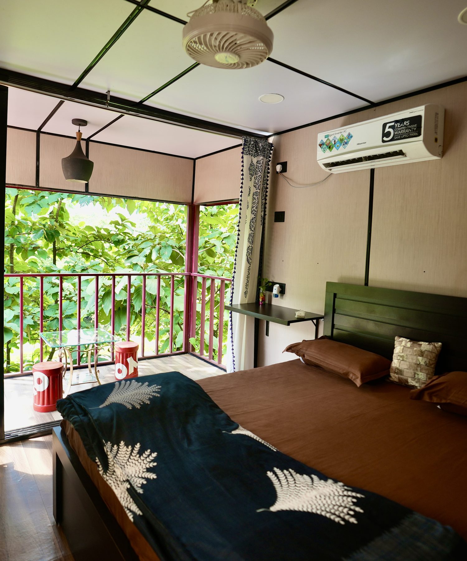 inside a container home, bed beside the full-height glass wall