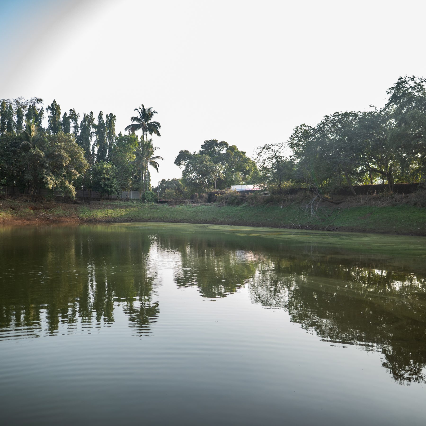 the lake at midday, hills reflected in still water