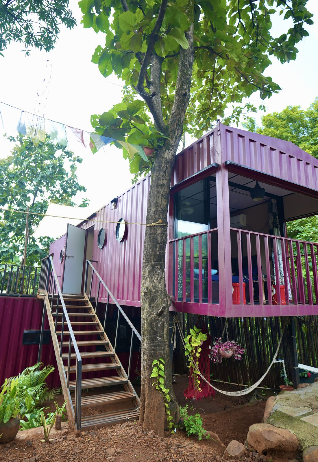 the container homes under the trees, stair up to the terrace