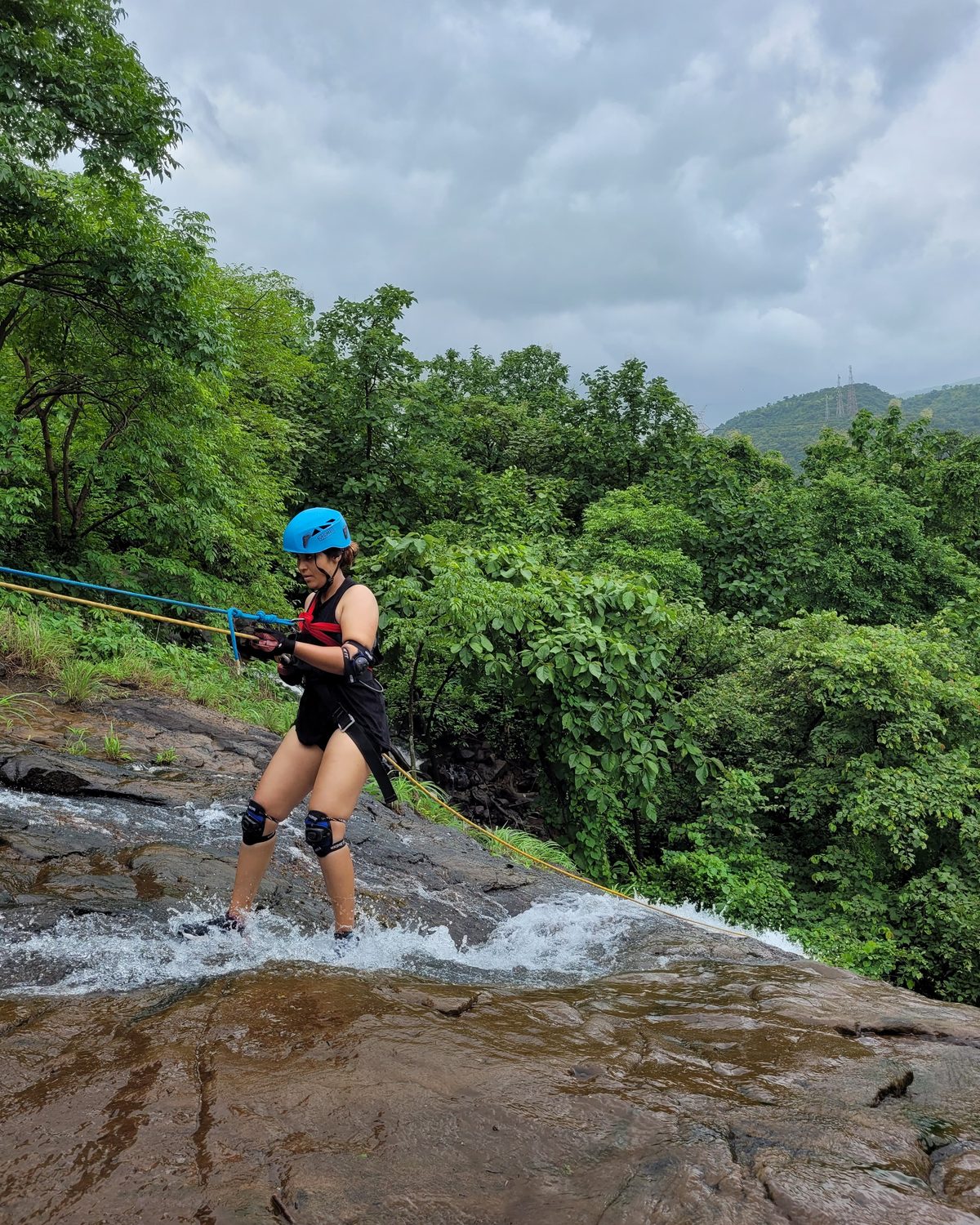 the waterfall running, a guest on the rope beside it