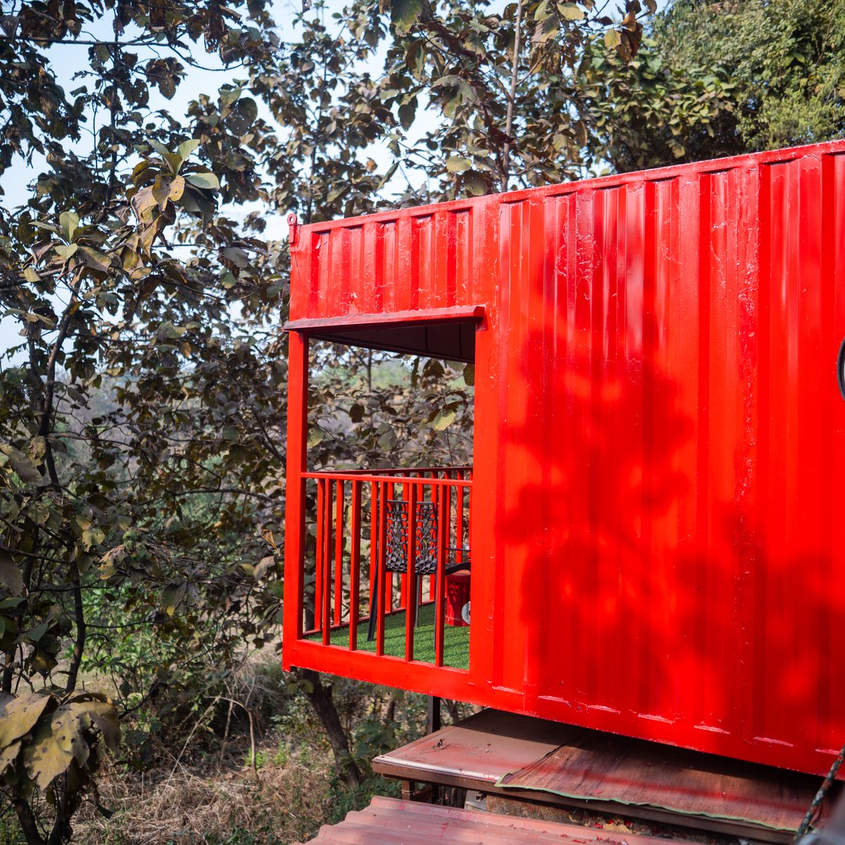 a shipping container set into the slope, deck framed out
