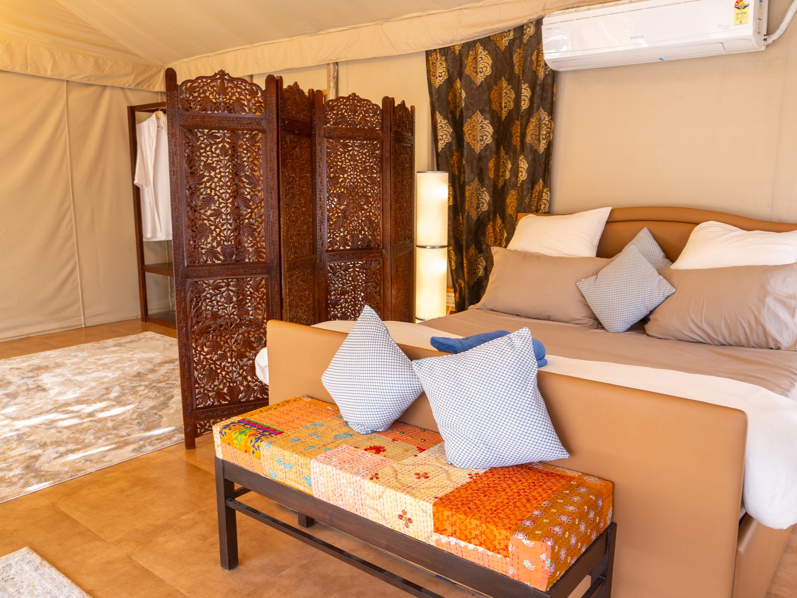 the suite's king bed behind a carved screen