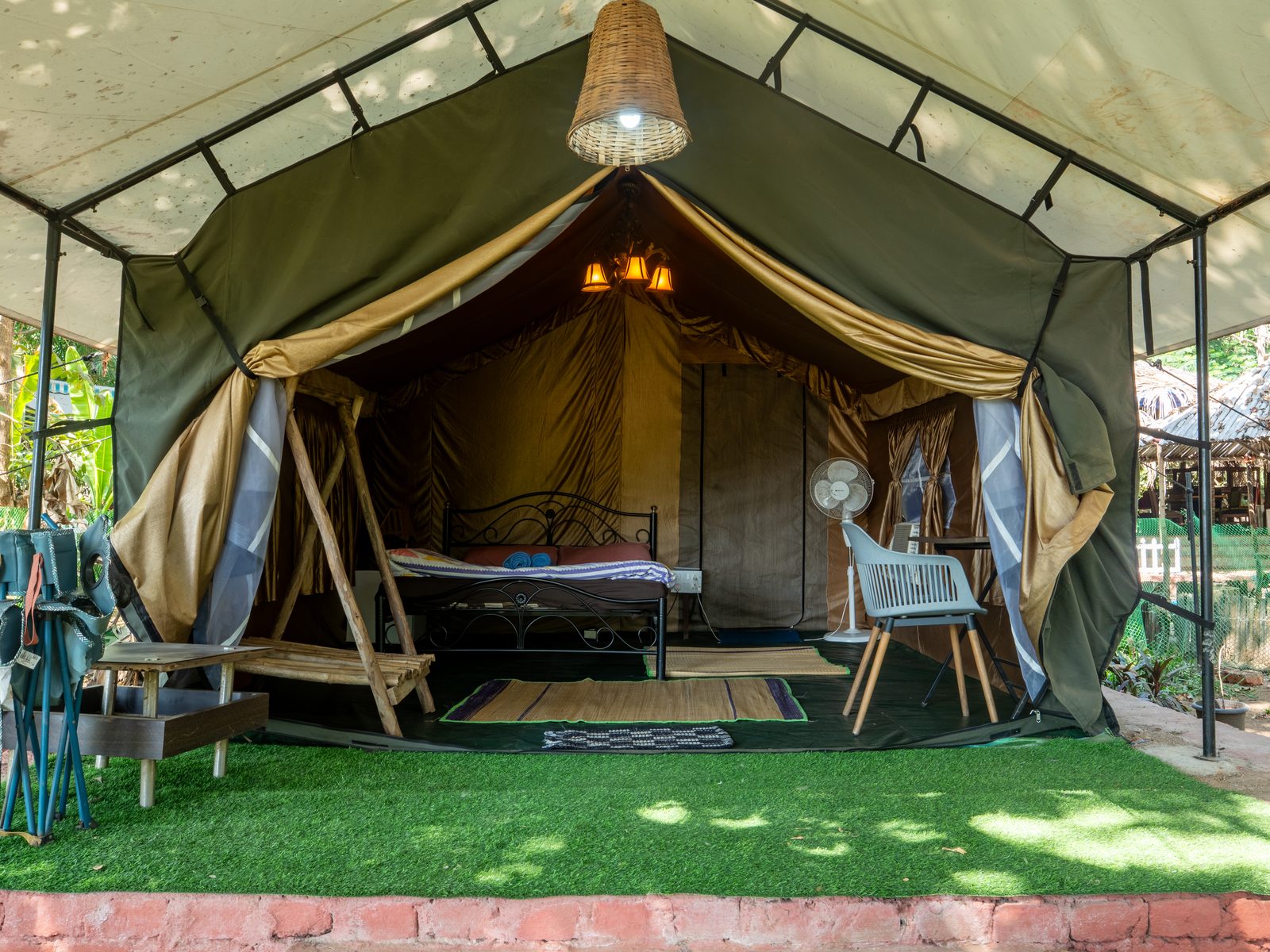 glamping tent interior with bed and lawn