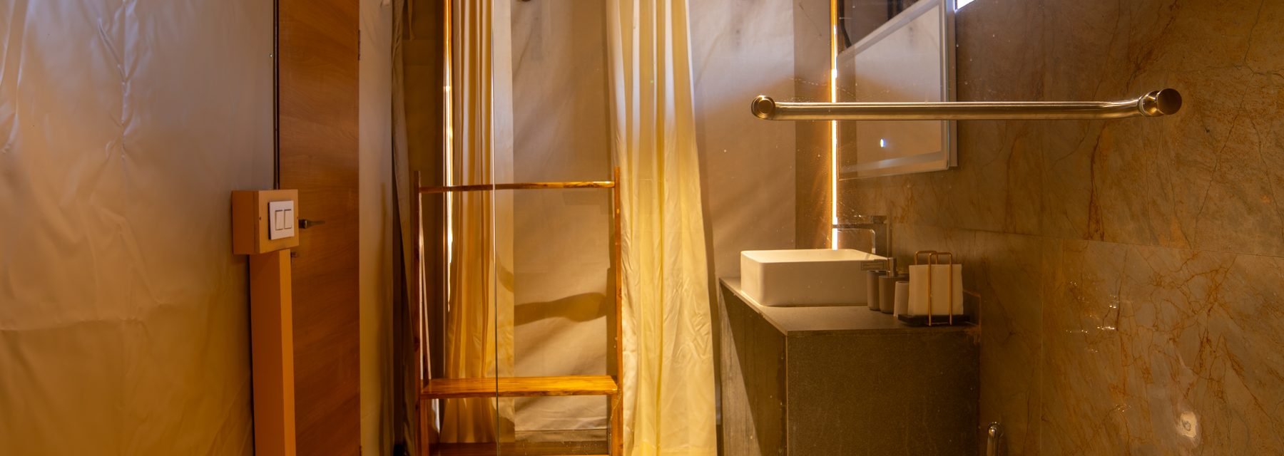 the marble ensuite, basin and rain shower behind the bed wall