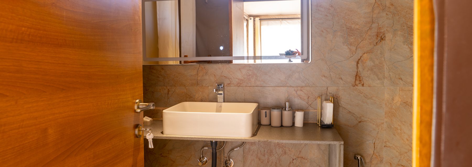 the tent's stone en-suite, basin and mirror