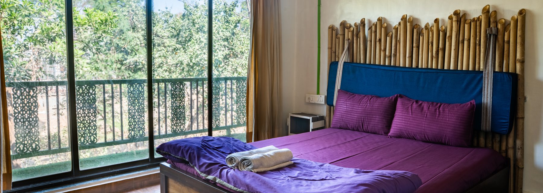 master bedroom with a full-height window onto the trees